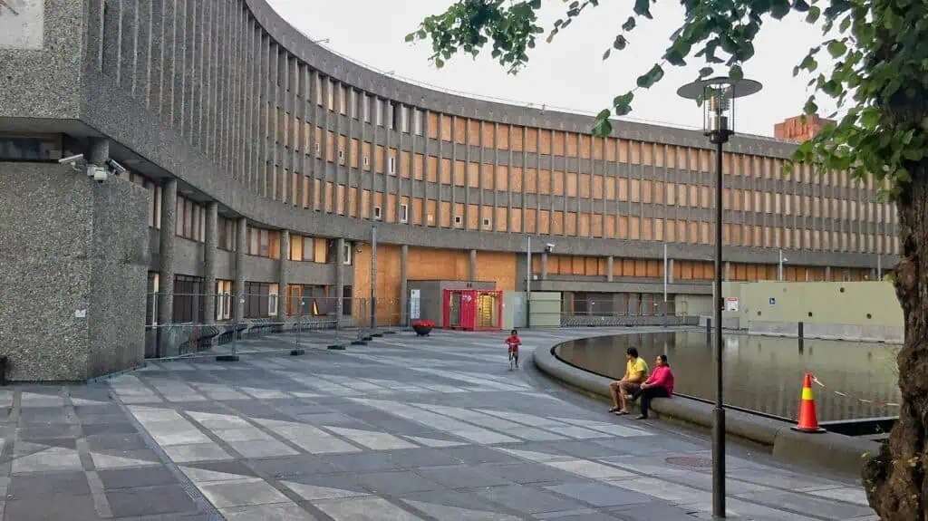 people sitting on concrete bench near brown concrete building during daytime